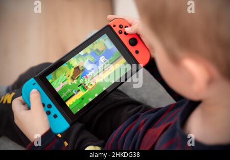 Wroclaw, Polonia - 27 GENNAIO 2022: Il ragazzo gioca a Nintendo Switch console. Nintendo Switch è una popolare console mobile. Foto Stock