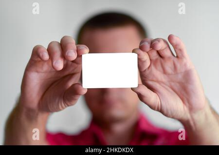 l'uomo mostra una carta di credito o un biglietto da visita bianco Foto Stock