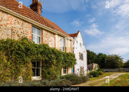 Scena stradale con cottage in stile locale a Cley-Next-the-Sea, un villaggio costiero sulla costa nord di Norfolk, East Anglia, Inghilterra Foto Stock