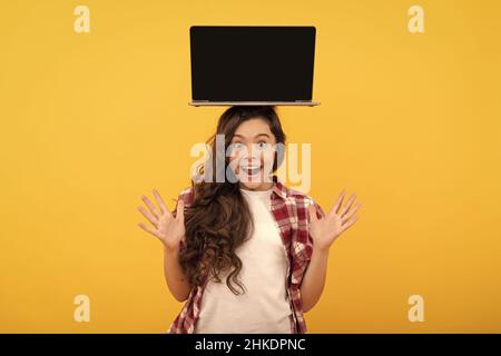 un bambino sorpreso che presenta il prodotto. presentazione della scuola sul computer. un bambino pronto per la lezione video. Foto Stock