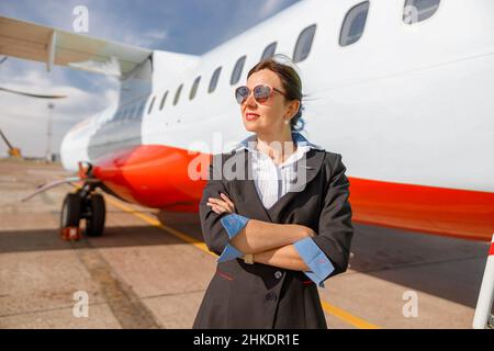 Donna stewardess o hostess in piedi all'aperto in aeroporto Foto Stock