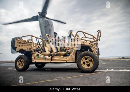 MAR DELLE FILIPPINE (Feb 3, 2022) Un'unità marina statunitense assegnata al distaccamento di ricognizione a dominio intero, 11th Marine Expeditionary Unit (MEU), prepara a caricare un veicolo polaris MrZR per tutti i terreni tattici su un MV-22B Osprey collegato al Marine Medium Tiltrotor Squadron (VMM) 165 (rinforzato), 11th MEU, Sul ponte di volo della nave d'assalto anfibio di classe Wasp USS Essex (LHD 2) a sostegno dell'esercizio Noble Fusion, 3 febbraio 2022. . In quanto unità preinstallata in grado di condurre operazioni anfibie, risposte alle crisi e limitate operazioni di emergenza, il MEU 11th conduce regolarmente corsi di formazione Foto Stock