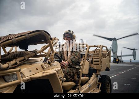 MAR DELLE FILIPPINE (Feb 3, 2022) Un'unità marina statunitense assegnata al distaccamento di ricognizione a dominio intero, 11th Marine Expeditionary Unit (MEU), prepara a caricare un veicolo polaris MrZR per tutti i terreni tattici su un MV-22B Osprey collegato al Marine Medium Tiltrotor Squadron (VMM) 165 (rinforzato), 11th MEU, Sul ponte di volo della nave d'assalto anfibio di classe Wasp USS Essex (LHD 2) a sostegno dell'esercizio Noble Fusion, 3 febbraio 2022. In quanto unità preinstallata in grado di condurre operazioni anfibie, risposte alle crisi e limitate operazioni di emergenza, il MEU 11th conduce regolarmente corsi di formazione per b Foto Stock