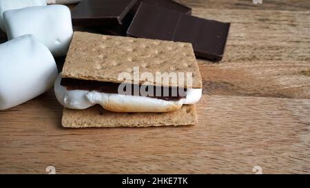 Fare s'Mores - cioccolato, marshmallows, e cracker graham su uno sfondo di legno. Foto Stock