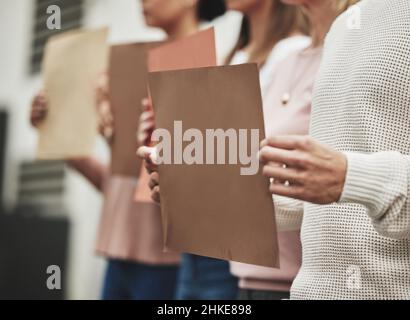 Questo è il punto in cui tracciiamo la linea. Un'immagine ritagliata di un gruppo di persone irriconoscibili che hanno dei segni mentre prendono parte a un raduno politico. Foto Stock