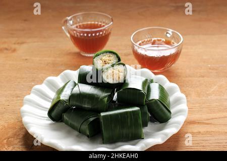 Il Lemper è un piatto tradizionale indonesiano a base di riso glutinoso o sticky, cotto al vapore con latte di cocco, con polpette di pollo all'interno e avvolto con Banana Foto Stock