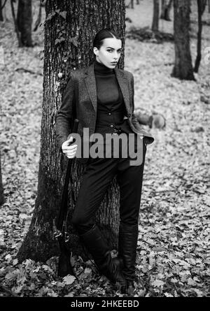 donna con arma. Bersaglio colpo. Cacciatore femminile in foresta. Ragazza con fucile. caccia al caccia al inseguimento. Negozio di armi. Caccia di successo. Sport di caccia. Moda militare Foto Stock