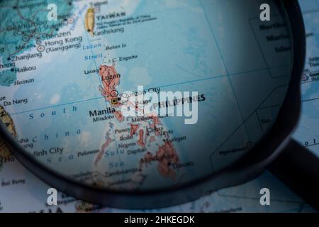 Filippine su una mappa del mondo attraverso lente d'ingrandimento. Filippine viaggio destinazione pianificazione bloccato Foto Stock