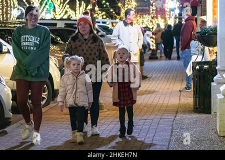 Prattville, Alabama, USA- 23 dicembre 2021: Due donne e due bambine camminano lungo le luci di festa nel centro storico di Prattville. Foto Stock