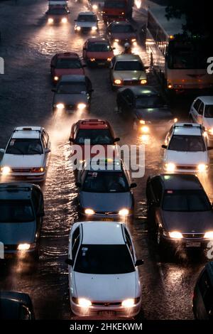 Ingorghi di traffico su strada allagata durante la pioggia pesante di notte, Manila, Filippine Foto Stock