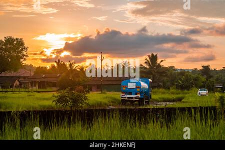 Ratnagiri, INDIA - 9 ottobre 2021 : petroliera in piedi sul terreno fatto strada villaggio con bella scena tramonto in villaggio indiano Foto Stock