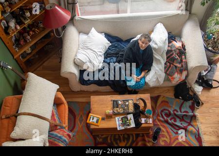 Una donna ispanica di 85 anni che dorme sul divano perché non può più salire le scale. Foto Stock