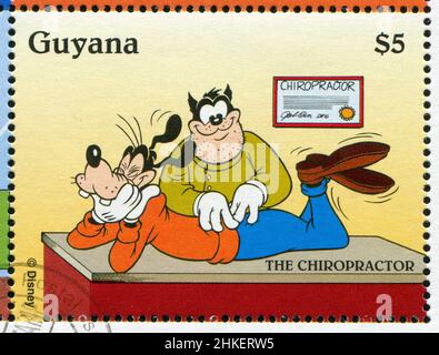 GUYANA - CIRCA 1995: Timbro stampato da Guyana, mostra Walt Disney personaggi, Goofy, Chiropractor, circa 1995 Foto Stock