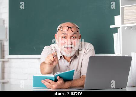 Insegnante esperto entusiasta che accoglie gli studenti al workshop. Concetto di educazione del nonno. Stupito volto sorpreso di divertente professore. Foto Stock