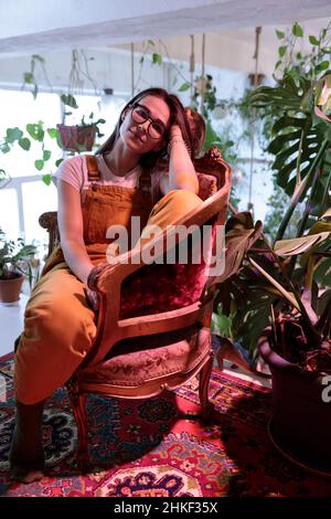 Giovane donna proprietario negozio di piante rilassarsi in boutique botaniche, gestione attività di giardinaggio Foto Stock