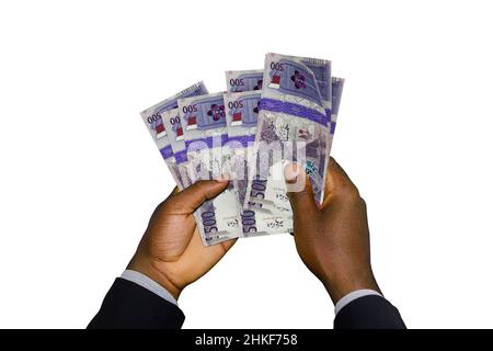 Mani nere in tuta con 3D note riyal del Qatar Foto Stock