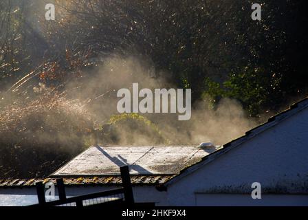 Nebbia causata dal sole di prima mattina che brilla durante la notte in inverno Foto Stock