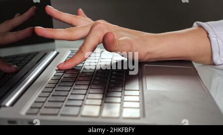 Donna disabile libera tipi articolo su laptop a casa Foto Stock