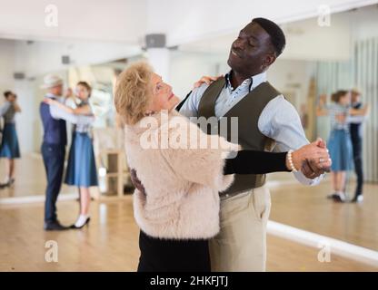 Uomo e donna anziana che ballano nella sala da ballo Foto Stock