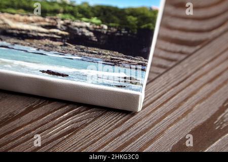 Stampa fotografica su tela stirata su telaio con bordo bianco su sfondo di legno Foto Stock