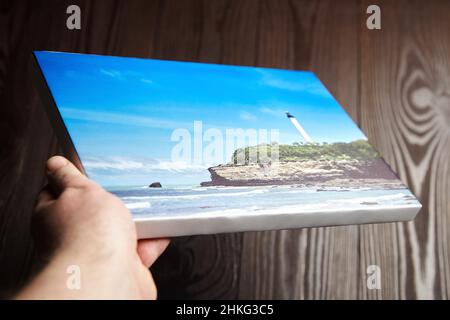 Stampa fotografica su tela allungata sulla cornice con bordo bianco in mano Foto Stock