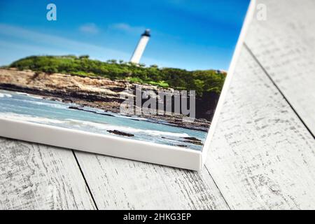 Stampa fotografica su tela stirata su telaio con bordo bianco su sfondo di legno Foto Stock