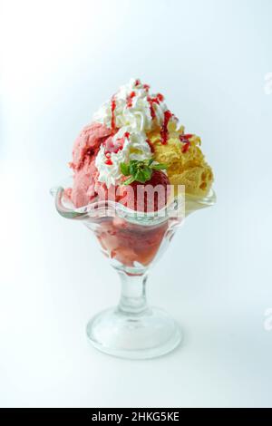 Tazza con tre palline di banana, panna e gelato alla fragola Foto Stock