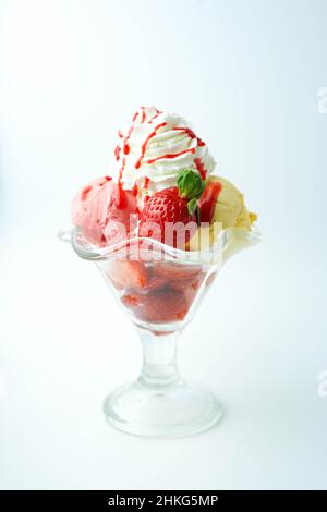 Tazza con tre palline di banana, panna e gelato alla fragola Foto Stock