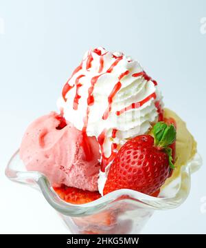 Tazza con tre palline di banana, panna e gelato alla fragola Foto Stock