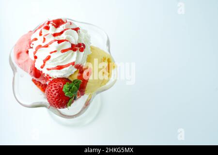 Tazza con tre palline di banana, panna e gelato alla fragola Foto Stock