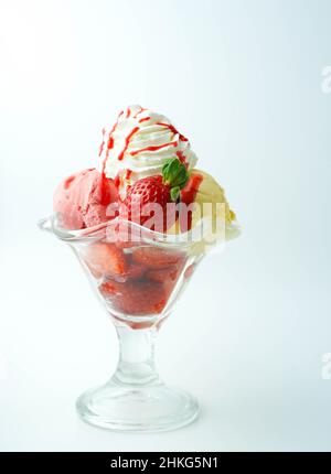 Tazza con tre palline di banana, panna e gelato alla fragola Foto Stock