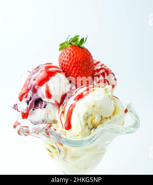 Tazza con tre palline di banana, panna e gelato alla fragola Foto Stock