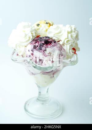 Tazza con tre palline di banana, panna e gelato alla fragola Foto Stock