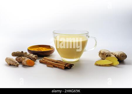 Latte d'oro di curcuma, zenzero, cannella e altro ancora, bevanda ayurvedica sana e medicina alternativa concetto, sfondo grigio chiaro con copia s Foto Stock