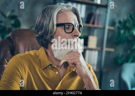 Ritratto di attraente concentrato ben curato uomo grigio-capelli leader economista pensiero al posto di lavoro stazione al chiuso Foto Stock