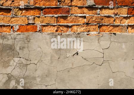 Vecchia parete di mattone con gesso caduto via. Sfondo di crack muro texture Foto Stock