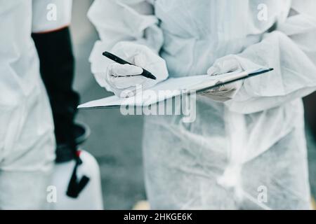 Operatori sanitari al lavoro. Shot di operatori sanitari che indossano tute di nocciolo che lavorano insieme per controllare un focolaio. Foto Stock