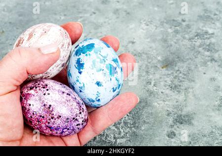 Donna mano che tiene le uova di pasqua dai colori vivaci. Foto Foto Stock