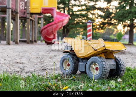 Vecchio camion giocattolo arrugginito abbandonato nel parco giochi. Concetto di infanzia povera. Foto Stock