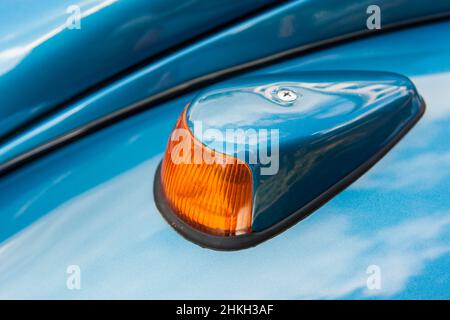 Vista ravvicinata in elevazione laterale dell'indicatore di direzione sinistro di una classica vettura tedesca blu metallizzata del 1960s e del 1970s. Foto Stock