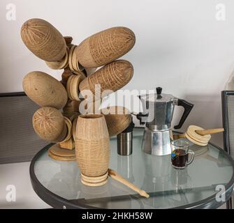 Una pentola di moka, una tazza di vetro e un macinacaffè di caffè e un set di goards bere si siedono su un piccolo tavolo sormontato di vetro in Nicaragua. Foto Stock