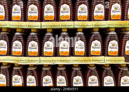 Bottiglie di miele runny Rowse in un supermercato Foto Stock