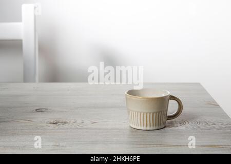 Piccola tazza di caffè su un tavolo beige. Posiziona per testo. Spazio di copia Foto Stock