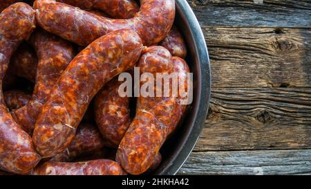 Salsicce fatte in casa su sfondo rustico di legno dall'alto Foto Stock