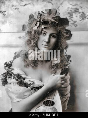 Fitz W Guerin, fotografo americano - giovane donna con viti nei capelli e intorno alle spalle. Lei sta tenendo un mandolino - 1902 Foto Stock