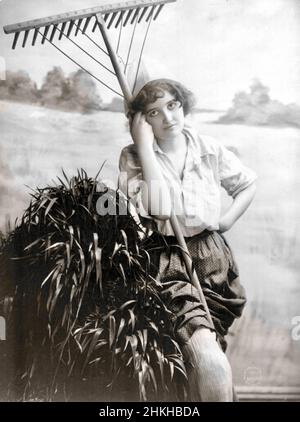 Fitz W Guerin, fotografo americano - Young Woman Modeling - in piedi con un rastrello - 1902 Foto Stock