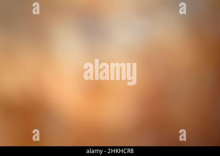 Sfondo marrone sfocato. Sfondo marrone sfocato con tinte arancioni. Foto Stock