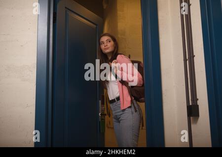 Zaino di trasporto turistico femminile che entra nella sua stanza ostello Foto Stock