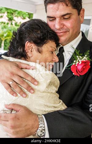 Miami Florida, matrimonio matrimonio matrimonio testimone di Geova, uomo ispanico donna cubano famiglia sposo madre figlio abbraccio Foto Stock