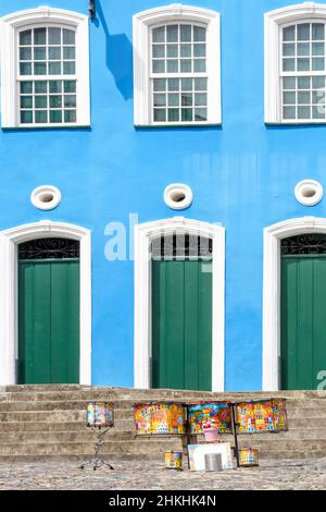 Tamburi colorati di fronte alla facciata in stile coloniale e scale sulle pendici di Pelourinho in Salvador, Bahia Foto Stock